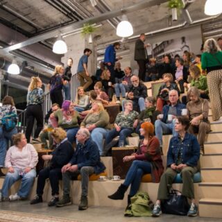 28 oktober 2024 | Wat was het leuk en succesvol!👏
Zenuwachtig waren we wel een beetje, of tenminste Iris. Maar alles was top voorbereid: gezellige locatie in hartje Maastricht met koffie en thee, zelf gebakken Limburgse linzenvlaai volgens Kevin's oma oud recept als welkomstraktatie, hulp van de moeder en zus van Iris bij de aanmeldbalie en Kevin die de avond op beeld ging vastleggen📷

De Limburger belde die middag nog op dat ze langs gingen komen. Want dit onderwerp zou wel meer mensen in de regio moeten bereiken! Maar toen alle 50 geïnteresseerden eenmaal een plekje op de tribune hadden gevonden, het muisstil was en de microfoon aansloeg was het ijs gebroken. We inventariseerden wie er in de zaal zat, vertelde over het verhaal en visie van La Finca, lieten twee andere initiatieven in Maastricht die collectief wonen aan het woord en maakte een aanzet tot match making. 

Deze avond resulteerde in 8 aanmeldingen voor potentiële kerngroepleden en meer dan 20 aanmeldingen voor de interesselijst wonen van La Finca. 🎯 Doel behaald! 

Jong en oud aanwezig, van mensen uit Maastricht, de regio en verder. Mensen die al ervaring hadden met collectief wonen of mensen die zelf bezig waren met een initiatief opzetten. Verder waren Rabobank en VKKL (vereniging kleine kernen Limburg) aanwezig. En dank aan @snsexpertisecentrummaastricht voor het beschikbaar maken van de locatie!

En nu? Even bijkomen en de avond herbeleven. Wat een energie en wat een mooie mensen ontmoet! Jack en Iris voelde gelijk een klik met een jong koppel, Gerjanne en Martijn. Die wilde we sowieso snel spreken! En een vrouw die we eerder gesproken hadden en die zelf een community in Portugal had opgezet, was er die avond ook! Met haar gingen we zeker ook verder praten.

Benieuwd wie er in de kerngroep komen?